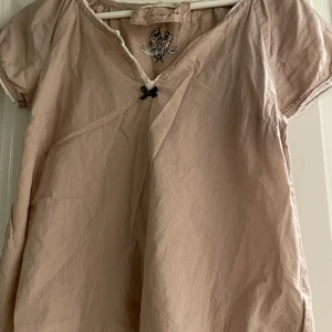 Odd Molly blus - storlek 1  - Beige Odd Molly blus i storlek 1 - motsvarar S. Något större i storleken, kan passa mindre M.   V-ringad med vita detaljer. 