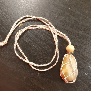 Halsband till kristaller - Detta är ett halsband gjort av mig till kristaller. Bandet runt halsen är ca 67cm. Kristall ingår inte. Det är en beige pärla och en typ blom aktig sak i båtten jag vet seriöst inte vad för färg den är. Det är öppnigen så du skjuter upp dem pärlorna.