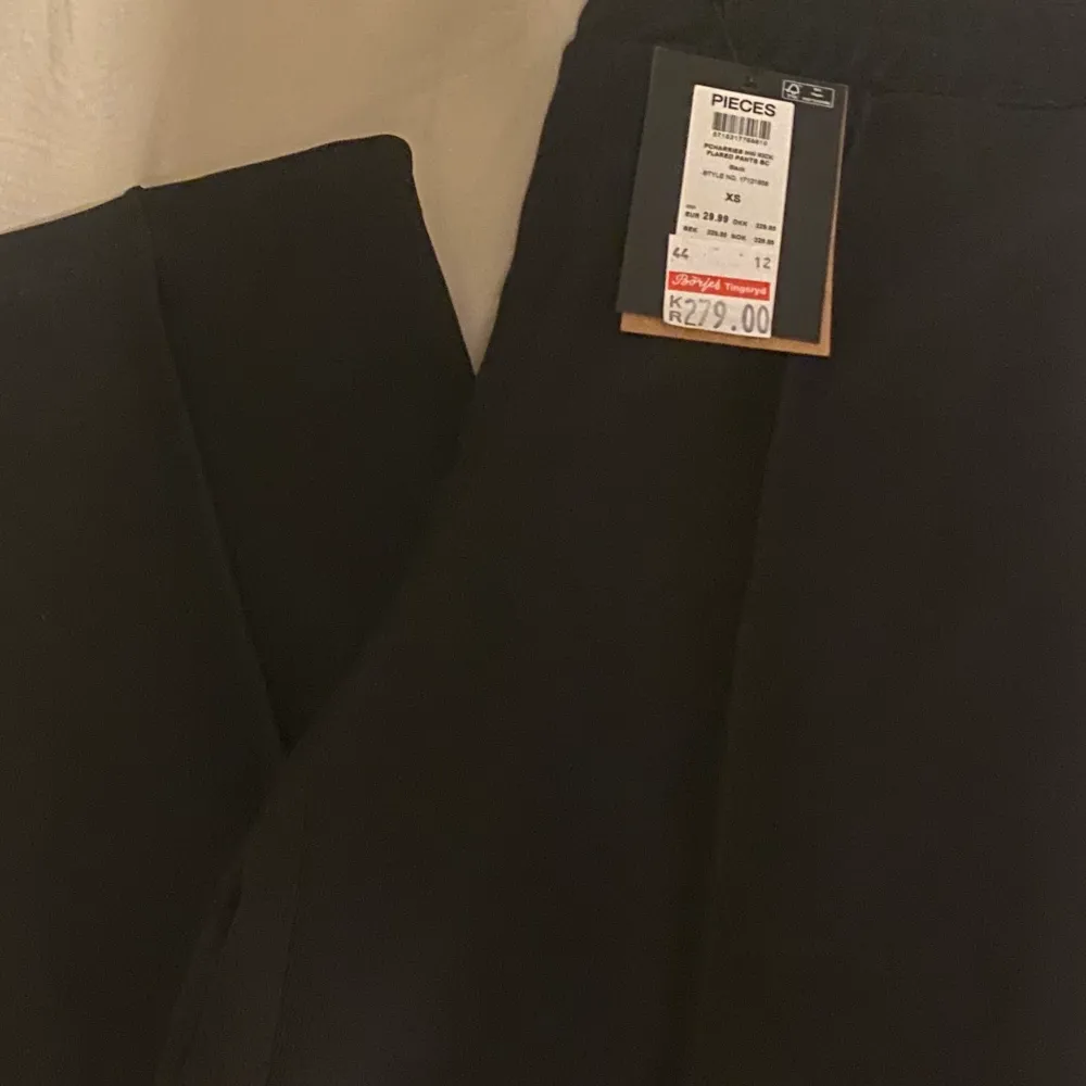 ett par svarta byxor med en textur på benen, de är i storlek XS och är aldrig använda (därav är lapparna kvar)💕 de är från märket PIECES och är likt kostymbyxor. Jeans & Byxor.