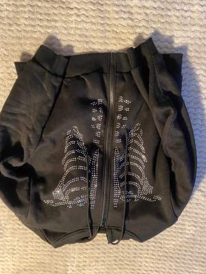 Svart zip up hoodie från SHEIN . Skallet med rhinestones. För mer bilder eller svar på frågor skriv. Köparen står för frakt.