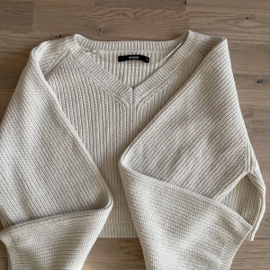 Stickad kort tröja - Fint skick på denna stickade tröja från bikbok i en härlig krämvit färg, kort så visar lite mage när man bär den om man inte har något under den, storlek xs men passar absolut small/medium oxå beroende på hur man vill att den ska sitta