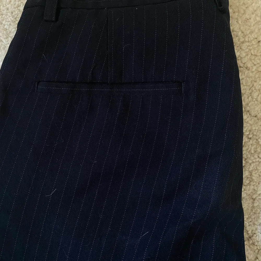 Ett par marinblå kostymbyxor med små vita streck längs med byxan. Knappt använda . Jeans & Byxor.