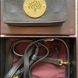Mulberry väska eller phonecase i modellen ”daria”. Svart skinn med gulddetaljer.  Axelrem medföljer. Kommer i originalpåse och orginalbox.