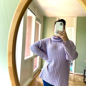 Stickad lila tröja - En långärmad ribbad tröja med hög turtleneck hals i ljuslila