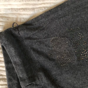 Gråa Juicy couture byxor  - Low waisted utsvängda Juicy couture byxor från 00-talet. Med rhinestones. Strlk Xs-s. 77 cm i innerbensmått