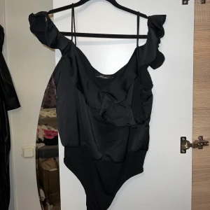 Svart body - Svart body med offshoulder volanger från Morel i storlek M, använt endast en gång.💞