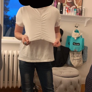 Vit t-shirt - Tröjan är en magtröja och är in sydd i mitten.