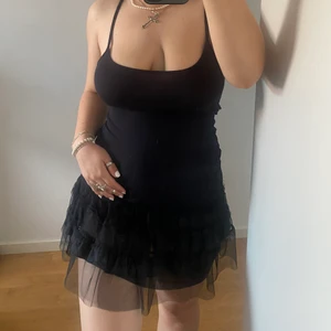 Svart klänning - !!Har fler svarta klänningar!! Säljer 3/4 svarta klänningar som jag köpte för en fest som hade temat ”Blackdress” och denna kom aldrig till användning tyvärr. Den sitter tajt men är ett jätte skönt material och har tyll volanger längst ned!💞