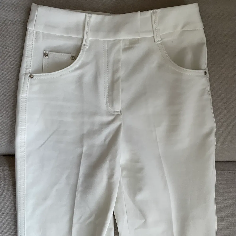 Vita bootcut kostymbyxor i stretchigt material och hög midja.  Använt men fint skick med någon synlig defekt på byxkanten då de är långa.. Jeans & Byxor.