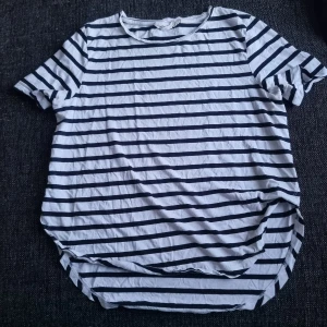 T-shirt - Randig T-shirt med längre baktill. Storlek L