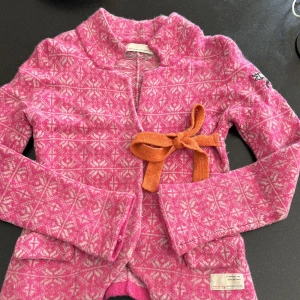 Ood molly  - Odd Molly Blenda Cardigan är fäst vid jacquardkofta med volanger i nederkanten och band som kan knytas till en vacker rosett för att stänga den.  En riktig skönhet!