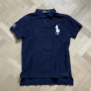 Ralph lauren polo  - Ralph lauren polo marinblå. Hyfsat bra skick, lite solblekt. US OPEN 2007 tennis polo kollektion. Säljs inte längre. Skriv för fler bilder! Nypris va runt 1500kr. 