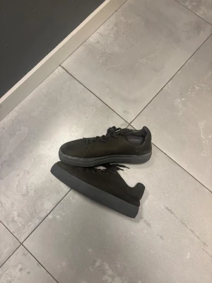 Svarta sneakers från Pavement, strl 41 - Säljer ett par  sneakers från Pavement i storlek 41. Skorna har grå sula och är gjorda i mocka med snörning framtill. Köpta på Joel i Borås kvitto finns. Pris kan diskuteras.