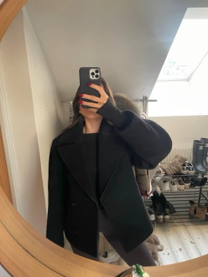 Svart jacka/ kort kappa - Svart jacka/ kort kappa i kavaj-liknande modell. 