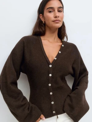 Brun stickad kofta med v-ringning - Snygg brun stickad kofta med v-ringning och vita knappar framtill. Stora mysiga armar. Jag har använt tröjan vid exakt 2 olika tillfällen. Som ny. Säljs pågrund av flytt så rensar garderoben köptes för 400kr från Gina 