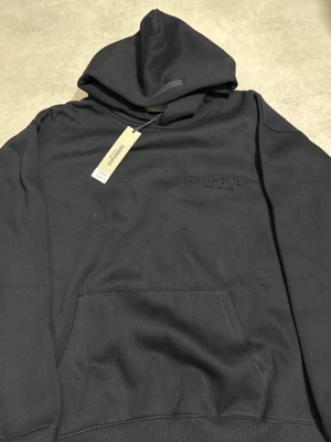 Svart ESSENTIALS hoddie  - Svart ESSENTIALS hoddie som e helt ny, storlek S