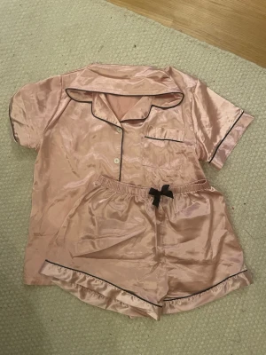 Silkes pyjamas  - En rosa silkes pyjamas med svarta detaljer