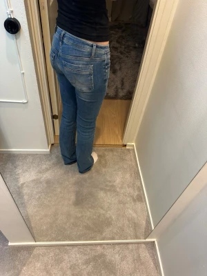 Blå jeans från LTB Valerie - Säljer ett par blå jeans från LTB Valerie med klassisk femficksdesign och smal passform. Jeansen har normal midja och utsvängda ben med lätt tvättad look. Materialet är mjukt jeans och de har snygga detaljer vid fickorna och linningen.