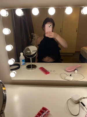 Svart volangig halterneck topp - Säljer en svart halterneck topp med flera lager volanger framtill. Toppen är croppad och har en öppen rygg med knapp i nacken. Perfekt för dig som gillar en lite mer edgy och trendig stil. Materialet känns lätt och luftigt. 