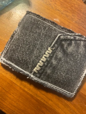 Svart jeansplånbok  - Säljer en handgjord plånbok i svart denim med synliga sömmar och råa kanter av Denimpocket