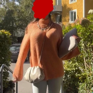 Stickad orange polotröja Gina Tricot - Supermysig stickad polotröja från Gina Tricot i en snygg orange färg. Tröjan har ribbad struktur, lång ärm och hög krage som ger en cool vibe. Perfekt att styla med jeans eller kjol för en trendig look. Första bilden är lånad!