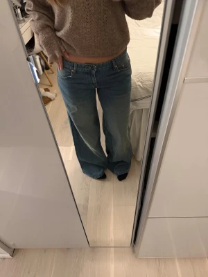 Wide low waist jeans från Motel rocks  - Säljer ett par ”smutsblåa” jeans från Motel rocks med breda ben och låg midja. De är aldrig använda och har prislappen kvar. Orginalpris är 833 kr, storlek W30/ L32
