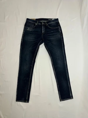 DONDUP JEANS - George - Hej! Säljer ett par riktigt snygga Dondup jeans i en mörkblå färg. Storlek 33. Modellen är George, en väldigt populär passform som sitter riktigt bra och är väldigt stilrent. Jeansen är i bra skick.  Hör gärna av er om ni har frågor! 