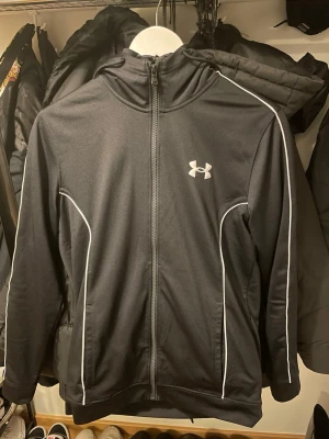 Under armour tracksuit+ extra tröja  - - Under armour tracksuit är i bra skick men den har en liten defekt på byxorna (som man ser på bilden), Pris utan extra tröja 550kr pris med extra tröja 679, Tracksuiten är i storlek S extra tröjan är i storlek M