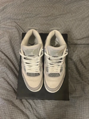 Nike Air Jordan 4 Retro Iron Grey - MÖTS OCKSÅ UPP Nike Air Jordan 4 Retro i färgen Iron Ore/Sail-Neutral Grey. Snygga sneakers med meshpaneler, grå mockadetaljer och silvriga accenter. Klassisk snörning och platt sula. Perfekt för dig som gillar stilrena och ikoniska sneakers TAR EMOT BYTEN MOT ANDRA FAST STORLEK 43.