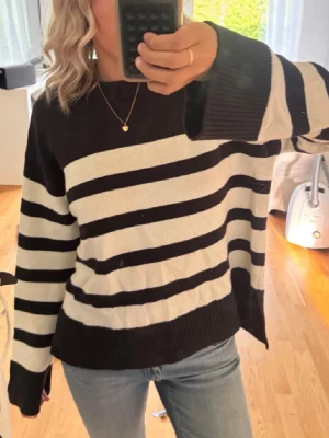 Stickad tröja  - Säljer en vit randig stickad tröja från Gina Tricot Young. Tröjan har breda ränder, ribbade muddar och rund hals. Perfekt för dig som gillar en chill och avslappnad stil. Passar till både jeans och kjol. Storlek 158-164, men passar Xs/S