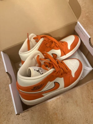 Nike Air Jordan 1 orange och vita - Nike Air Jordan 1 sneakers i orange och vitt med klassisk svart swoosh. Nypris : 1499kr , i mycket bra skick !  Storlek : 36 ( 23 cm) 