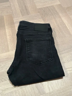 Jack & Jones jeans - Säljer ett par svarta jeans från Jack&Jones. Modellen heter Glenn och är slim fit. Storlek 30/30. Perfekt för dig som gillar en stilren och enkel look. Hör av dig vid funderingar!