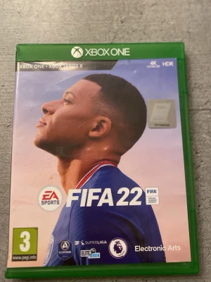 FIFA 22 Xbox One/Xbox Series X - FIFA 22 till Xbox One/Xbox Series X i mycket gott skick. Komplett med fodral, skiva och bonuskod. Upplev realistisk fotbollsgrafik i 4K Ultra HD och HDR. Stöd för singleplayer, multiplayer och online-spel. Perfekt för fotbollsfans!