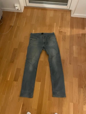 Grå jeans Tiger of Sweden  - Säljer ett par grå jeans från Tiger of Sweden, modell Ivy Fuel i storlek 34/34. Sitter snarare som ett par 33/33. Skönt stretchmaterial. Perfekt för dig som gillar en enkel och clean look med lite edge.