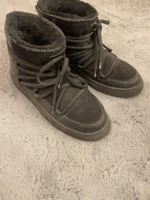 Svarta boots med snörning och päls - Säljer ett par svarta boots med snörning och pälsfoder. Skorna har en rund tå och platt sula, samt breda snören som går runt hela skon. Perfekta för kalla dagar och har en robust look som passar till många stilar. Kan eventuellt tänka mig gå ner i pris