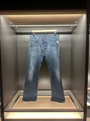Replay jeans  - Säljer ett par klassiska blå jeans från Replay med raka ben och normal passform. Jeansen har fem fickor, snygga slitningar och Replay-logga på myntfickan. Materialet är robust denim i bomull och färgen är mörkblå med ljusare tvättade partier. Storleken är W32 och L34. Hör av er vid frågor eller funderingar 