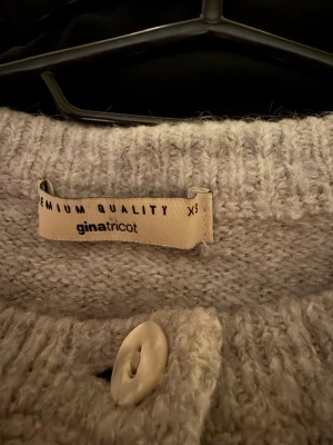 Grå stickad kofta från Gina Tricot - Mysig grå stickad kofta från Gina Tricot i storlek XS. Koftan har rund hals, långa ärmar och knappar framtill. Perfekt för lager-på-lager och chill dagar. Materialet är mjukt och ger en skön känsla mot huden.