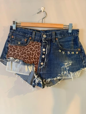 Levis shorts - Storlek: W32 L30. Skick: Jättebra!! Säljer ett par jätte coola retro Levis shorts med leopard mönster och nitar! Shortsen går ej att köpa i butik. 