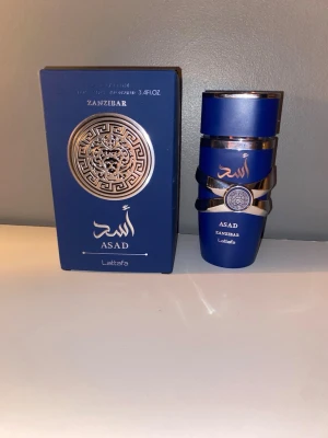 Lattafa Asad Zanzibar parfym fraktar på lördag om köp sker idag - Asad Zanzibar från Lattafa är en Eau de Parfum med en volym på 3.4 fl. oz. (100 ml). Ingredienser: alkohol, parfym, vatten. Tillverkad i U.A.E. Snygg design och perfekt för dig som vill sticka ut. Snabb handel