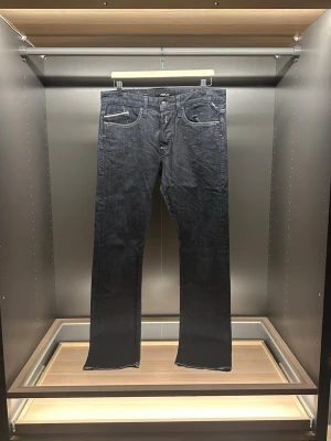Replay waitom jeans - Snygga mörkblå jeans från Replay med klassisk femficksdesign och kontrastsömmar. Modellen har raka ben och normal passform, med Replay-logga på fickan och läderpatch bak i midjan. Perfekt för dig som gillar stilrena och tidlösa jeans. Hör av er vid minsta lilla fundering eller andra frågor.