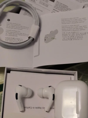 AirPods Pro 2 - Apple AirPods Pro med laddningsetui, extra öronkuddar och laddningskabel. Produkten ser ut att vara i mycket gott skick, komplett med originalförpackning och tillbehör. Aktiv brusreducering och trådlös anslutning för bästa ljudupplevelse.