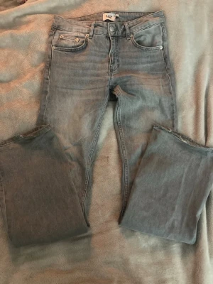Grå lågmidjade bootcut jeans  - Snygga grå jeans från 157 med bootcut passform och låg midja. Klassisk femficksdesign och raka ben med lite utsvängning nedtill. Jeansen är tillverkade i mjukt denimtyg och har en neutral grå färg som är lätt att matcha med olika stilar.