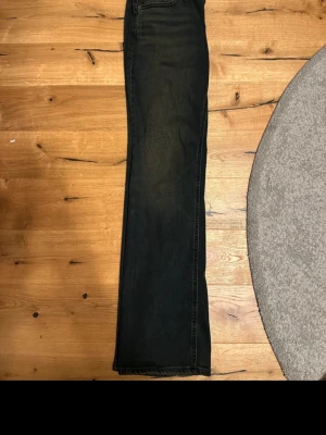 Levi's Superlow Bootcut jeans, svart - Svarta Levi's Superlow Bootcut jeans i klassisk bootcut-modell med låg midja. Jeansen har fem fickor, bälteshällor och Levi's ikoniska läderpatch bak. Materialet är slitstarkt jeans och passformen är normal med snyggt fall över skon. Storlek 27x32 som nya. Nypris 949 kr 