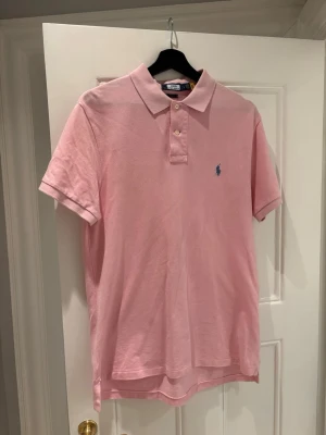 Rosa pikétröja från Polo Ralph Lauren - Säljer en rosa pikétröja från Polo Ralph Lauren i storlek L, slim fit. Använd ett par gånger men inga skador, har även en liknande pike i blått på min profil 