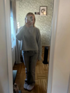 Grå stickad tröja - Säljer en grå stickad tröja som är kortare i midjan. Passar som mys tröja men även som en mysig touch  på en snygg outfit.