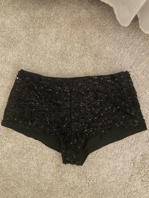Svarta paljettshorts - Svarta lågmidjade paljettshorts / glittershorts. Storlek S skulle jag säga! Passar perfekt för nyår/temafester osv✨