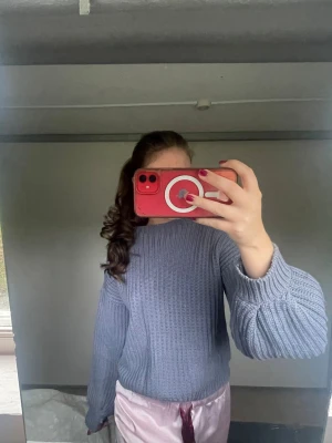 Ljusgrå/blå stickad tröja med ballongärmar - Supermysig ljusgrå stickad tröja med breda ballongärmar och ribbad struktur. Det finns ett litet hål uppe vid vänstra delen av kragen, men går att laga. Från NA-KD st.XS