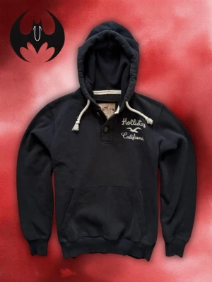 Svart hoodie Hollister med tryck - Svart hoodie med tryck och vit bodrad text på bröstet från hollister | Mycket bra skick | Size S recommended | Längd: 65cm Axelbredd: 45cm Armlängd: 64cm | Modell 162cm, 60kg