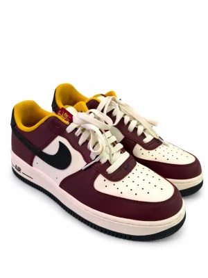 Limited Edition - Nike Air Force - Nike Air Force 1 sneakers i vinrött och vitt med svart swoosh och gul insida. Klassisk låg modell med snörning, perforerad tå och platt sula. Ovandel i skinn och mocka, svart yttersula och vita skosnören. Perfekt för dig som gillar färgstarka sneakers.