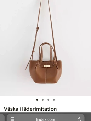 Brun axelväska från Lindex - Snygg brun axelväska i läderimitation från Lindex som är slutsåld på hemsidan. Fint skick!! 